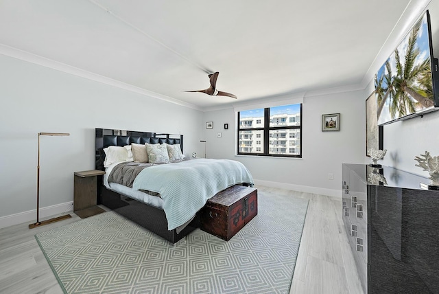 bedroom featuring ceiling fan, ornamental molding, and light wood-type flooring