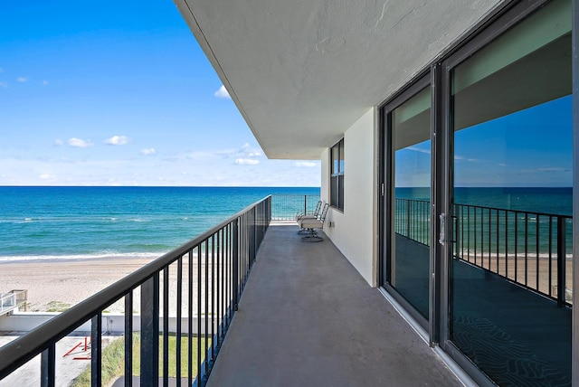 balcony with a water view and a beach view