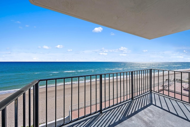 balcony with a water view and a beach view