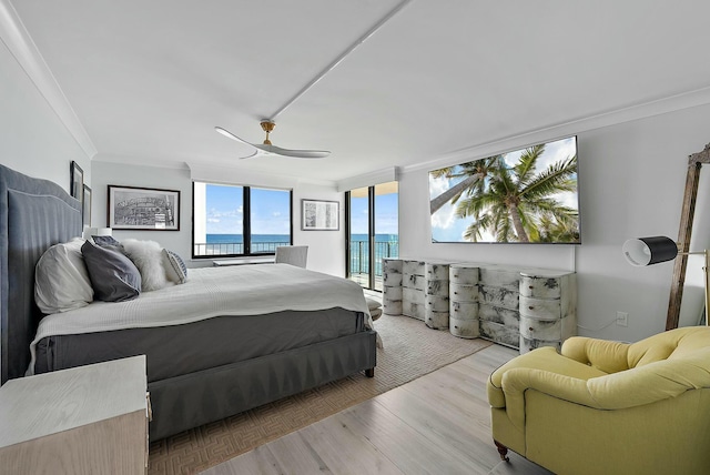 bedroom featuring a water view, light wood-type flooring, ornamental molding, ceiling fan, and access to exterior