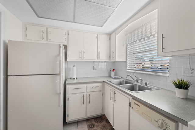 kitchen with white cabinetry, sink, white appliances, and tasteful backsplash