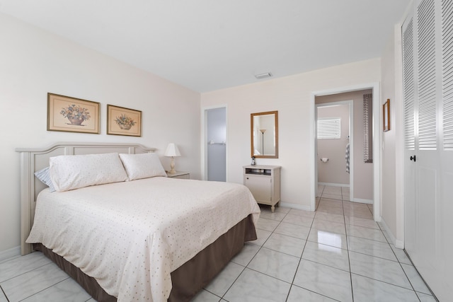 bedroom featuring light tile patterned floors and a closet