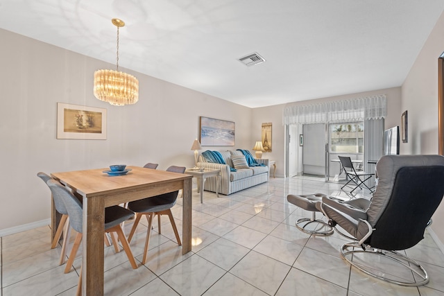 dining room with light tile patterned floors and an inviting chandelier