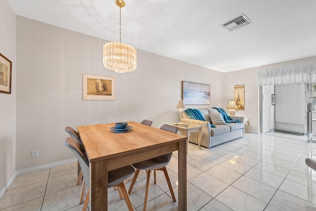 dining space featuring light tile patterned flooring and a notable chandelier