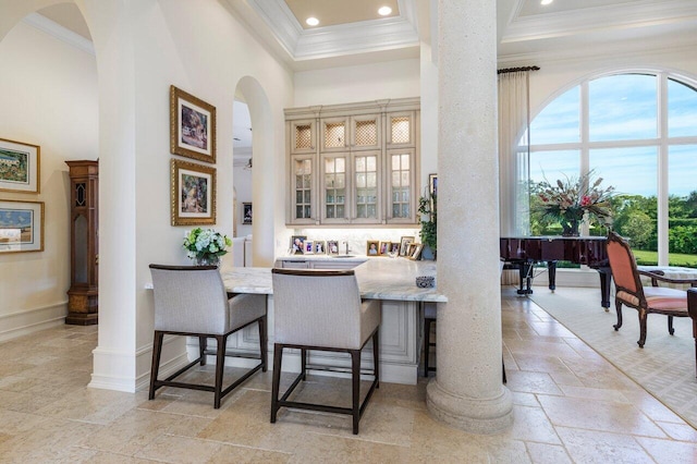 dining space featuring a towering ceiling and ornamental molding