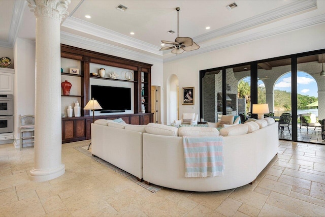 living room with a tray ceiling, crown molding, ceiling fan, and ornate columns