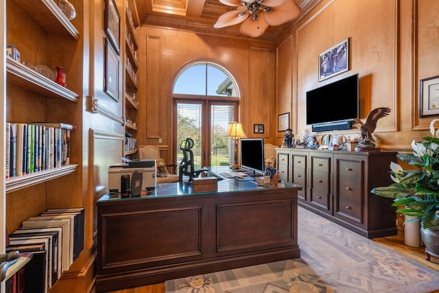 office space with coffered ceiling, crown molding, wooden walls, and ceiling fan