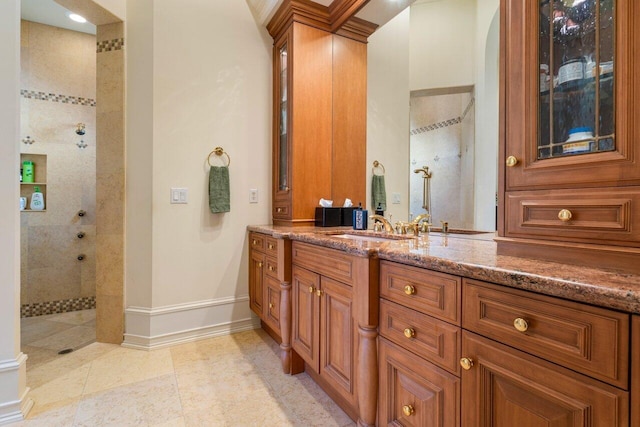 full bath featuring baseboards, a walk in shower, vanity, and tile patterned flooring