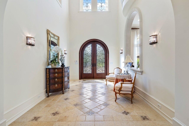 entryway with french doors and a towering ceiling