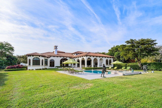 back of property featuring stucco siding, an outdoor pool, a yard, and a patio area