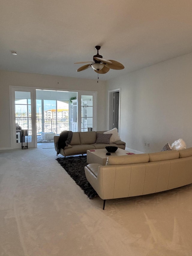 carpeted living room with ceiling fan