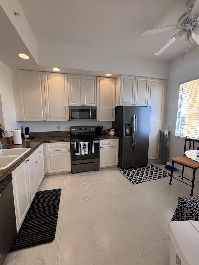 kitchen featuring sink, light tile patterned floors, ceiling fan, stainless steel appliances, and white cabinets