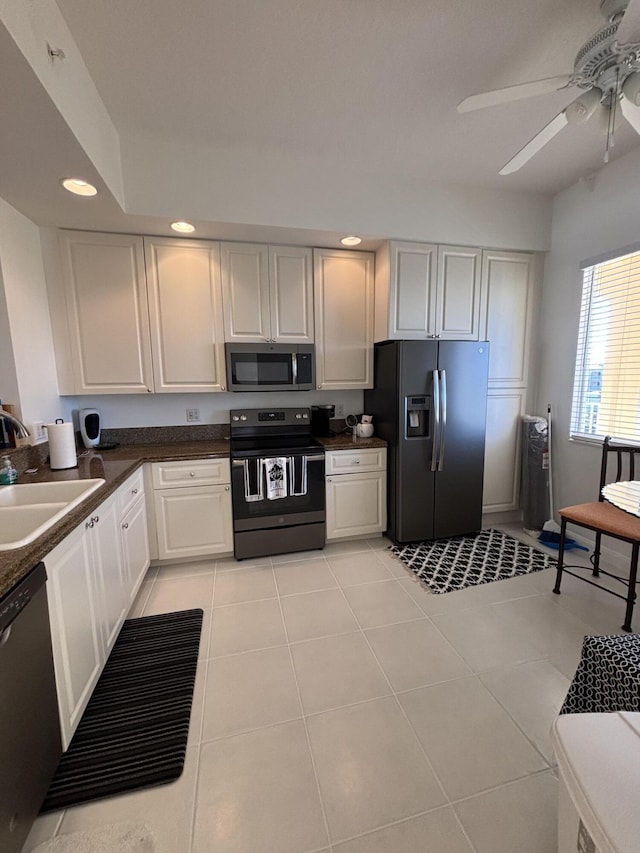 kitchen featuring sink, white cabinetry, light tile patterned floors, ceiling fan, and stainless steel appliances