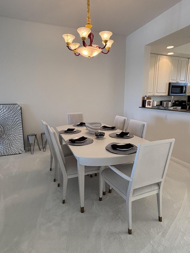 dining area with light colored carpet and a notable chandelier