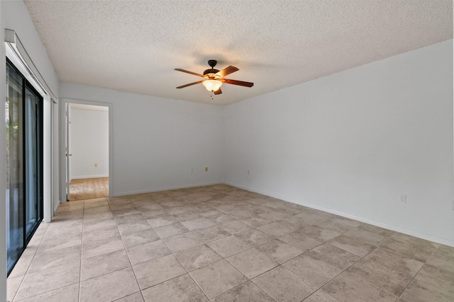 tiled empty room featuring ceiling fan and a textured ceiling