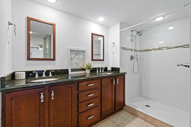 bathroom with vanity, a tile shower, and tile patterned floors