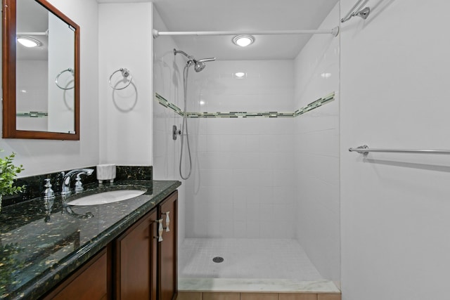 bathroom with vanity and a tile shower