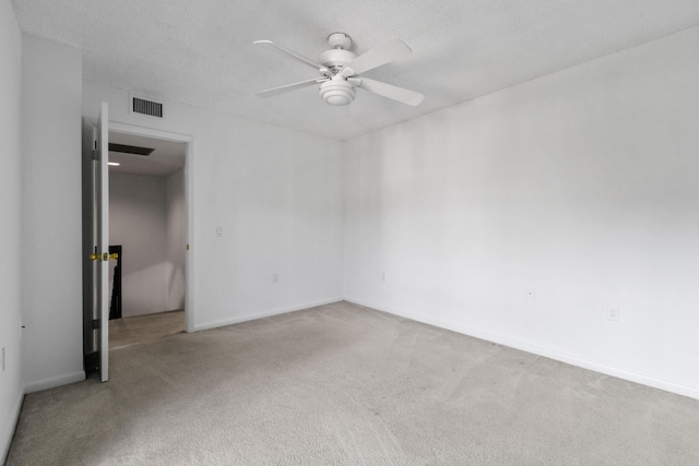 carpeted spare room with ceiling fan and a textured ceiling