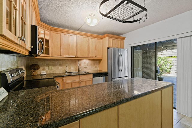 kitchen with sink, backsplash, dark stone counters, stainless steel appliances, and a textured ceiling