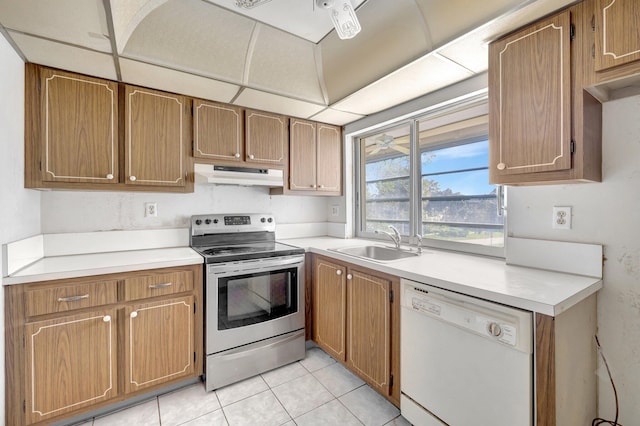 kitchen featuring under cabinet range hood, a sink, stainless steel range with electric cooktop, light countertops, and dishwasher