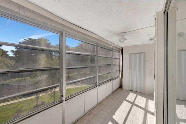 unfurnished sunroom with ceiling fan