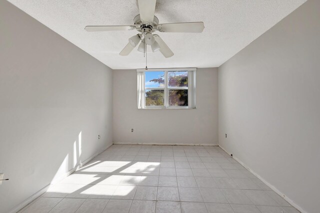 9101 Lime Bay Blvd Unit 312, Tamarac, FL 33321 - spare room with a textured ceiling, ceiling fan, light tile patterned flooring, and baseboards