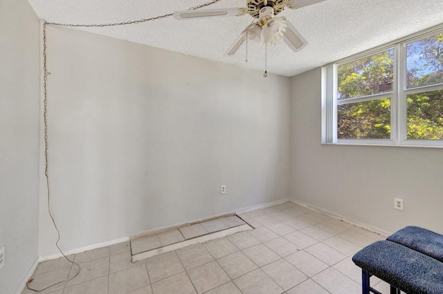 9101 Lime Bay Blvd Unit 312, Tamarac, FL 33321 - spare room with ceiling fan, a textured ceiling, light tile patterned floors, and baseboards