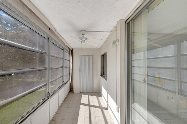 unfurnished sunroom featuring a ceiling fan