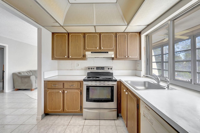 kitchen with white dishwasher, stainless steel electric range, light countertops, under cabinet range hood, and a sink