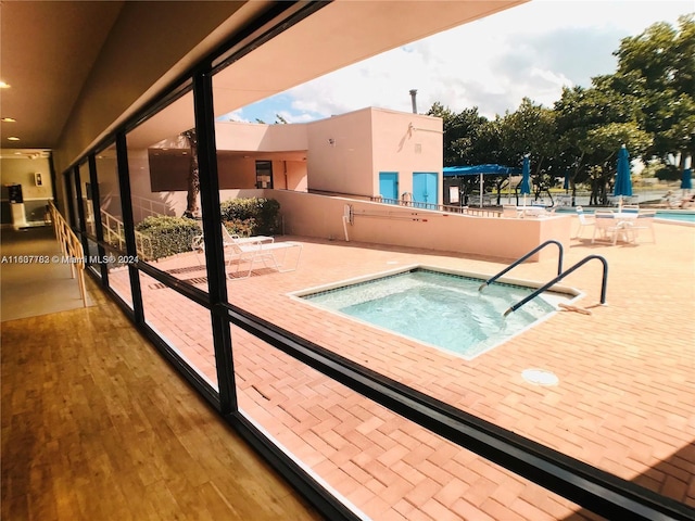 view of pool featuring a patio and a hot tub