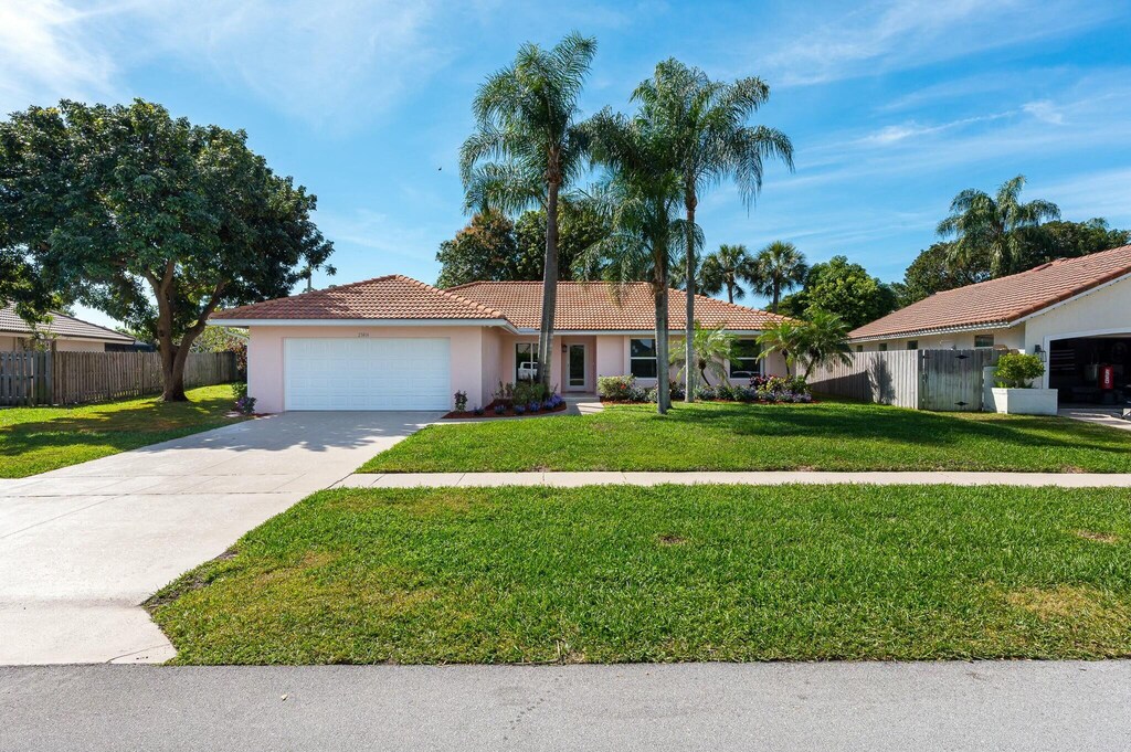 single story home with a yard and a garage