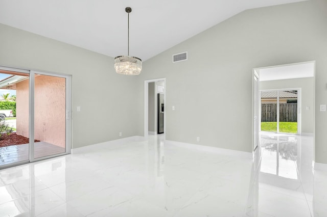 spare room featuring lofted ceiling and a notable chandelier