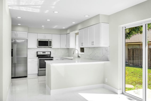 kitchen featuring tasteful backsplash, appliances with stainless steel finishes, sink, and white cabinets