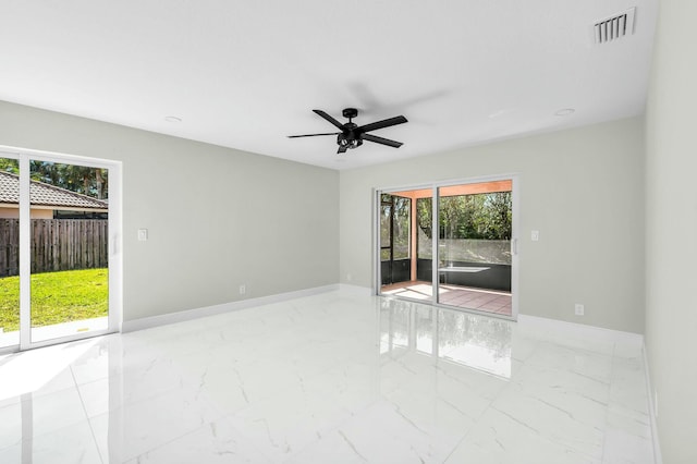 spare room featuring plenty of natural light and ceiling fan