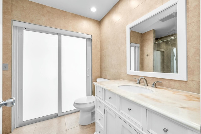 bathroom with tile walls, vanity, an enclosed shower, tile patterned floors, and toilet