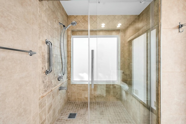 bathroom featuring a shower with shower door