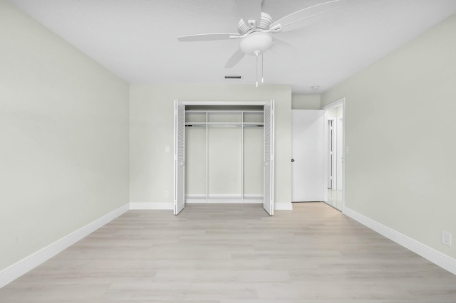 unfurnished bedroom with light hardwood / wood-style flooring, a closet, and ceiling fan