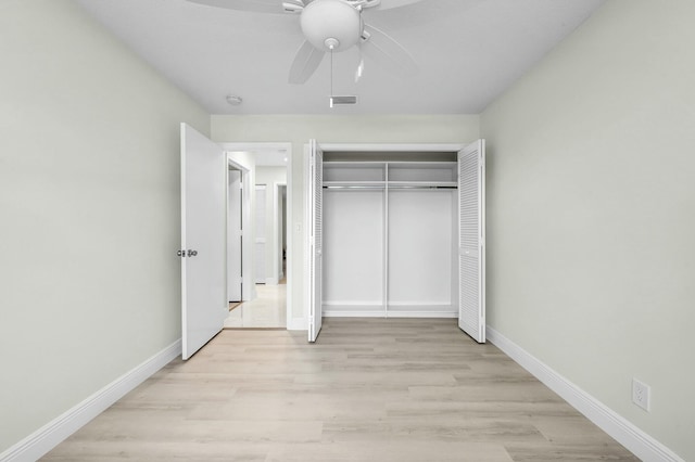 unfurnished bedroom featuring ceiling fan, light hardwood / wood-style floors, and a closet