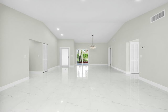 unfurnished room with lofted ceiling and an inviting chandelier