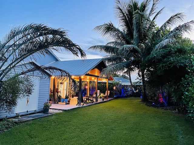 yard at dusk featuring a patio area