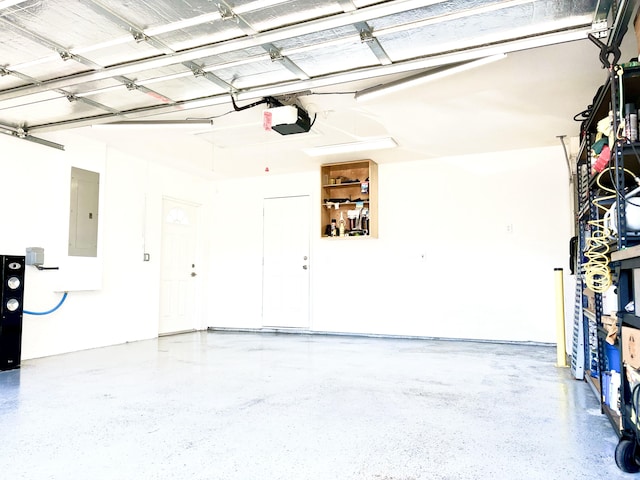 garage with a garage door opener and electric panel