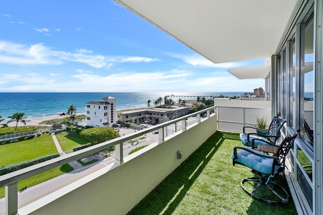 balcony featuring a water view and a view of the beach