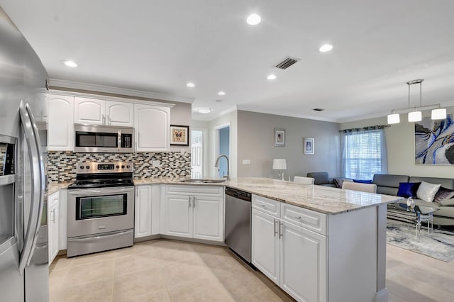 kitchen featuring sink, hanging light fixtures, stainless steel appliances, white cabinets, and kitchen peninsula