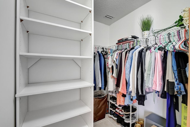 spacious closet with light tile patterned floors