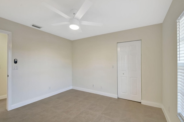 empty room featuring light tile patterned floors and ceiling fan