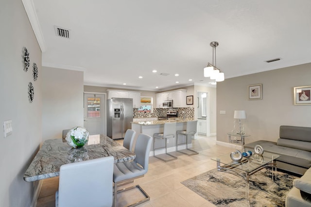 living room with ornamental molding and light tile patterned floors