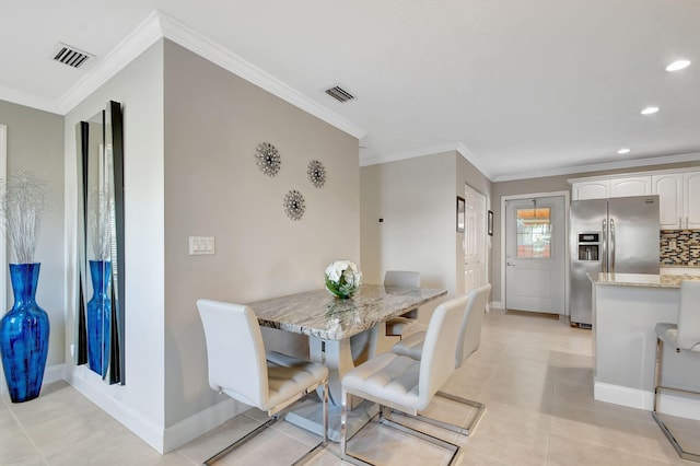 tiled dining area featuring ornamental molding