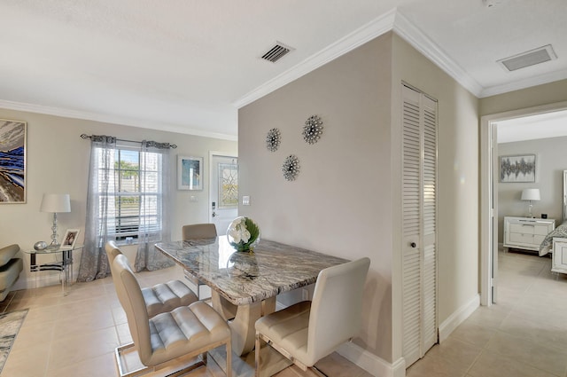 dining space with light tile patterned floors and ornamental molding