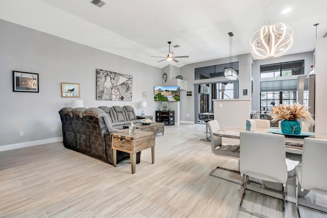 living room featuring ceiling fan with notable chandelier