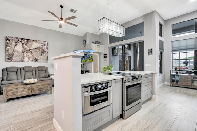 kitchen featuring ceiling fan, pendant lighting, wall oven, and electric stove